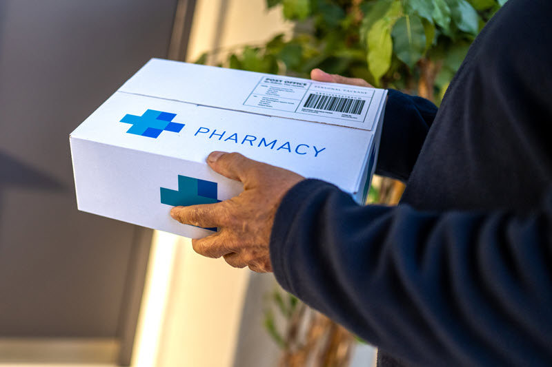 Male holding pharmacy delivery box